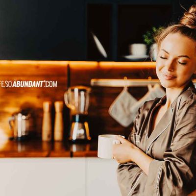 Morning Routine - Beautiful Young Happy Woman Standing In Kitchen Wearing Silk Pajamas - Life So Abundant®